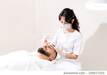 Ultrasound facial cleansing for young handsome man in professional beauty clinic. 108017283