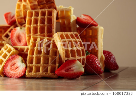 Belgian waffles with strawberries on a beige background. 108017383