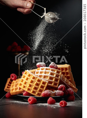 Belgian waffles with raspberries sprinkled with powdered sugar. Belgian waffles with raspberries sprinkled with powdered sugar. 108017385