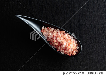 Pink salt on a black ceramic table. 108017391