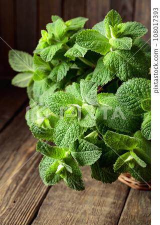 Fresh mint in a basket on an old wooden table. 108017393