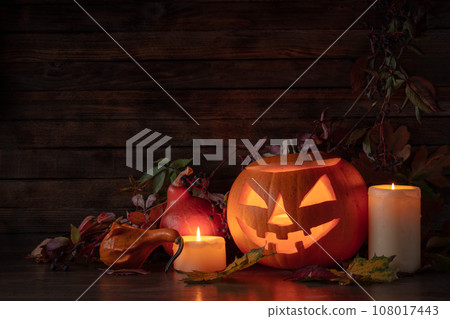 Halloween pumpkin head jack lantern with dried-up leaves. 108017443