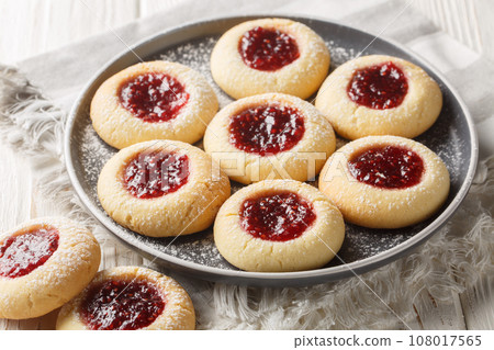 Hallongrottor Swedish Thumbprint Cookies closeup on the plate on the wooden table. Horizontal 108017565
