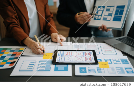 UX developer and ui designer brainstorming about mobile app interface wireframe design with customer breif and color code at office.. 108017659