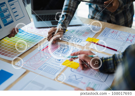 UX developer and ui designer brainstorming about mobile app interface wireframe design with customer breif and color code at office. with virtual icon. 108017693