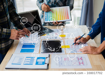 UX developer and ui designer brainstorming about mobile app interface wireframe design with customer breif and color code at office. with virtual icon. 108017702