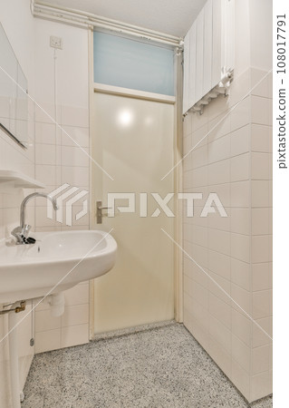 a small bathroom with a sink and toilet paper dispensed on the floor next to a white door a small bathroom with a sink and toilet paper dispensed on the floor next to a white door 108017791