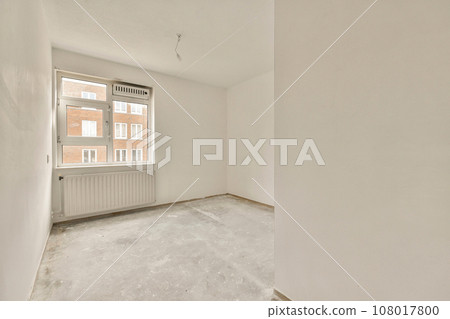 an empty room with white walls and no one person standing on the floor in front of the window looking out 108017800