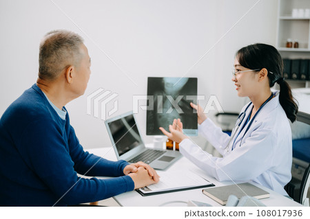 Serious Asia female doctor using clipboard is delivering great news talk discuss results or symptoms with female patient in clinic or hospital . Serious Asia female doctor using clipboard is delivering great news talk discuss results or symptoms with female patient in clinic or hospital . 108017936