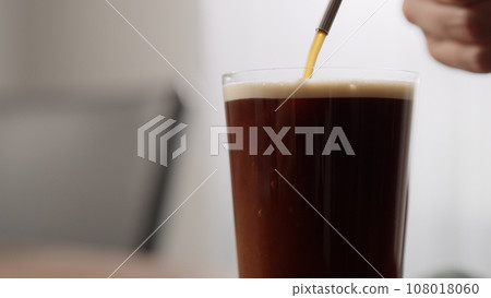 making nitro coffee in thin glass on walnut table 108018060
