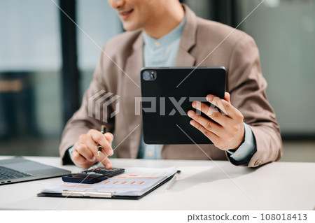 Close up of businessman or accountant hand typing laptop working to calculate on desk about cost at modern office.. Close up of businessman or accountant hand typing laptop working to calculate on desk about cost at modern office.. 108018413