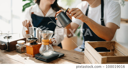 Cute couple, male and female barista working in coffee shop Barista working at cafe Alternative ways of brewing coffee.    . 108019016