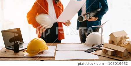Engineer desk with object paper and tablet with blurry engineer teamwork hardworking to consults about their building project.. 108019682