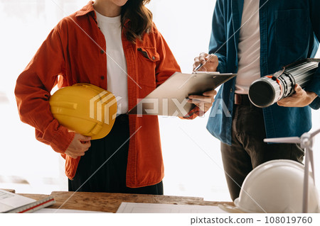 Construction team shake hands greeting start new project plan behind yellow helmet on desk in office center to consults about their building project... Construction team shake hands greeting start new project plan behind yellow helmet on desk in office center to consults about their building project... 108019760