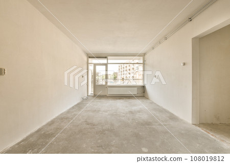 an empty room with no one on the wall or floor to see if it is in need of repair work an empty room with no one on the wall or floor to see if it is in need of repair work 108019812