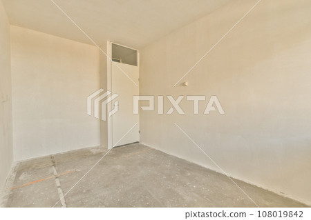 an empty room with white walls and no one door on the other wall there is a hole in the floor 108019842