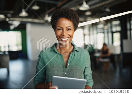 Half-length portrait of cheerful African American businesswoman in business attire holding a tablet. Happy smiling young lady, successful entrepreneur or employee working in office or coworking cafe. 108019928