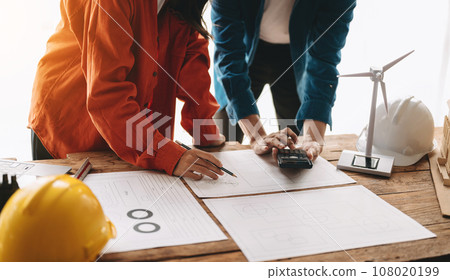 Creative architect projecting on the big drawings in the dark loft office 108020199
