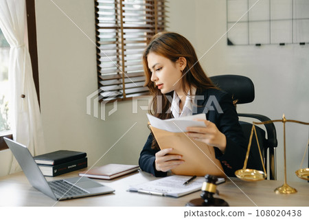 Attractive young lawyer in office Business woman and lawyers discussing contract papers laptop and tablet with brass scale on  desk in modern office. 108020438