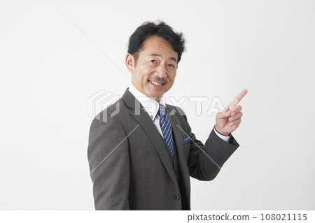 Middle-aged businessman pointing to the left, white background 108021115