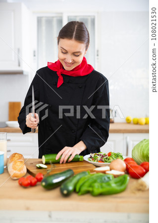 Female chef preparing vegetable salad, cutting vegetables 108021530