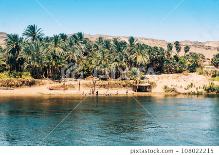 Friendly Locals Waving from Nile Shore to Cruise Ship. Egypt Summer Travel Friendly Locals Waving from Nile Shore to Cruise Ship. Egypt Summer Travel 108022215