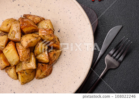 Delicious crispy fried potato wedges with salt, spices and herbs 108022246