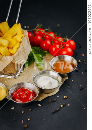 Set of different bowls of various dip sauces to french fries on dark background Set of different bowls of various dip sauces to french fries on dark background 108022901