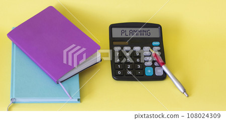 Text on a calculator planning near notepads on a yellow background. Business concept. 108024309