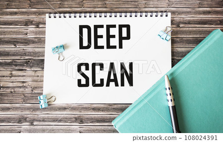 The text DEEP SCAN is written on a notebook, next to a diary, a pen and paper clips The text DEEP SCAN is written on a notebook, next to a diary, a pen and paper clips 108024391