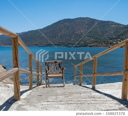 Wooden chair overlooking the blue sea at Pomos harbor, Cyprus Wooden chair overlooking the blue sea at Pomos harbor, Cyprus 108025378