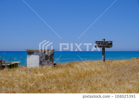 Abandoned wooden pigeon nest and other construction in a barley field overlooking the sea at Argaka, Cyprus Abandoned wooden pigeon nest and other construction in a barley field overlooking the sea at Argaka, Cyprus 108025391