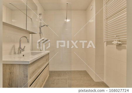 a bathroom with a sink, mirror and shower head mounted on the wall above the sink is a towel rack 108027724