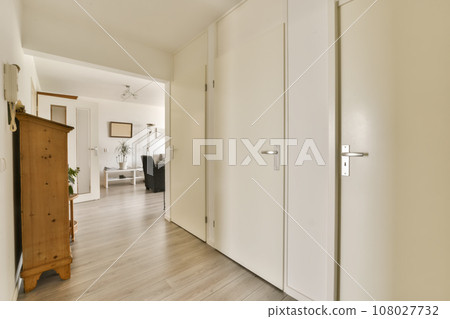 an empty room with white walls and wood flooring in the middle part of the room, there is a door leading to another 108027732