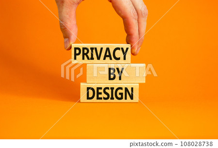 Privacy by design symbol. Concept words Privacy by design on wooden blocks on a beautiful orange table orange background. Businessman hand. Business finacial and privacy by design concept. Copy space. Privacy by design symbol. Concept words Privacy by design on wooden blocks on a beautiful orange table orange background. Businessman hand. Business finacial and privacy by design concept. Copy space. 108028738