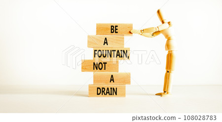 Be fountain not drain symbol. Concept words Be a fountain not a drain on wooden block. Beautiful white table white background. Businessman icon. Business be fountain not drain concept. Copy space. 108028783