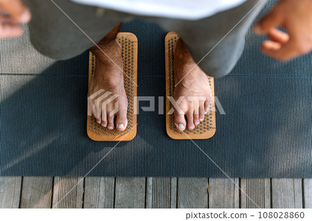 Sadhu board. Man standing on nails. Male bare feet on nails. Yoga practice. 108028860