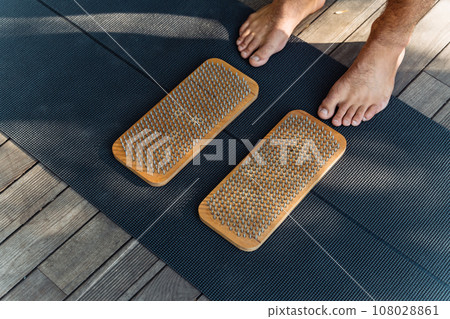 Sadhu board and standing on nails. Male bare feet near needle boards. Yoga practice. 108028861