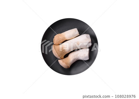 Pleurotus eryngii mushrooms on a dark concrete background Pleurotus eryngii mushrooms on a dark concrete background 108028976