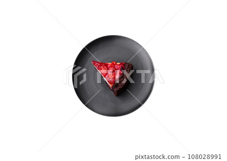 Beautiful tasty sweet slice of cheesecake with cherry on a ceramic plate 108028991