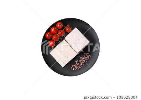 Delicious fresh ricotta cheese cut into slices with vegetables, salt and spices Delicious fresh ricotta cheese cut into slices with vegetables, salt and spices 108029004