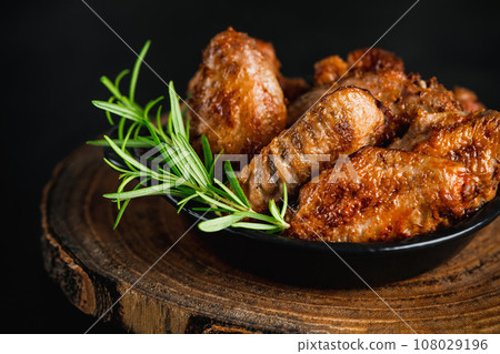 Semi-finished chicken wings on a dark background.Half-finished. Quick cooking at home. Fast food.Chicken wings fried until half cooked, semi-finished product.Semi-finished chicken wings lightly fried. Semi-finished chicken wings on a dark background.Half-finished. Quick cooking at home. Fast food.Chicken wings fried until half cooked, semi-finished product.Semi-finished chicken wings lightly fried. 108029196
