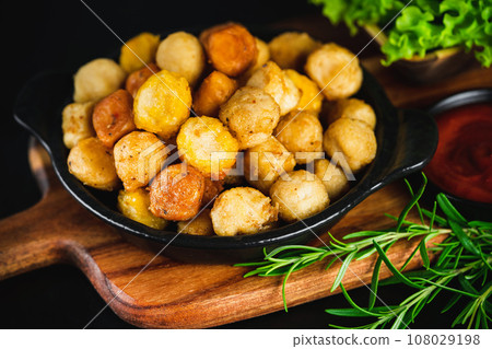 Assorted Breaded Chicken nuggets.Semi-finished chicken variety chicken nuggets on a dark background with fresh herbs. Semifinished. Quick cooking at home. Fast food. Breaded chicken nuggets. 108029198