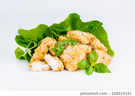 Breaded chicken nuggets. Breaded Chicken Inner Fillet with green lettuce leaves on a White Background,Chicken Breaded Raw Meat,Fillet.Fast homemade food at home.Chicken breaded schnitzels.Fast cooking 108029381
