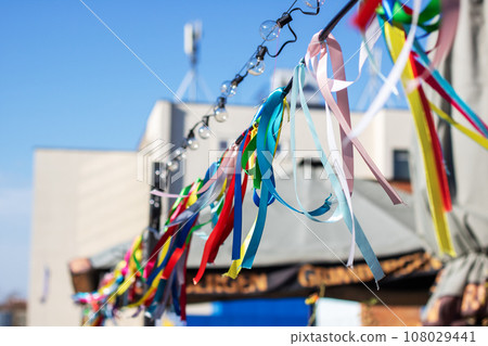 Colorful ribbons on rope on background of blue sky Colorful ribbons on rope on background of blue sky 108029441