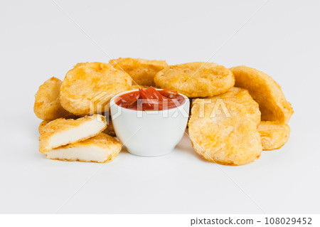 Chicken Breaded Fillet. Breaded chicken nuggets. Fast homemade food at home. Chicken breaded schnitzels. Breaded Chicken Inner Fillet on a White Background,Chicken Breaded Raw Meat. Fast cooking. 108029452