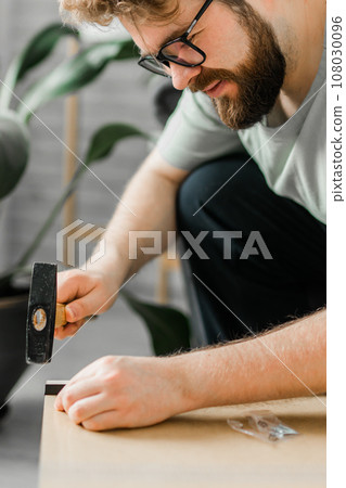 Portrait of man assembling furniture close-up. Do it yourself furniture assembly at home 108030096
