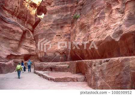 Kayon Sik. Bewin, dressed in traditional clothing, walks along the canyon wall. Petra Jordan Kayon Sik. Bewin, dressed in traditional clothing, walks along the canyon wall. Petra Jordan 108030952