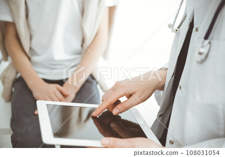 Doctor and child patient. The doctor is using tablet computer and is ready to examine the boy. The concept of ideal health in medicine Doctor and child patient. The doctor is using tablet computer and is ready to examine the boy. The concept of ideal health in medicine 108031054