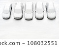 Cover winter parking lot cars under snow covered cars winter season. Snowy row of cars snow background winter time. Top view. Cold weather. Snowbound, Snow weather conditions. Above view. White design 108032551